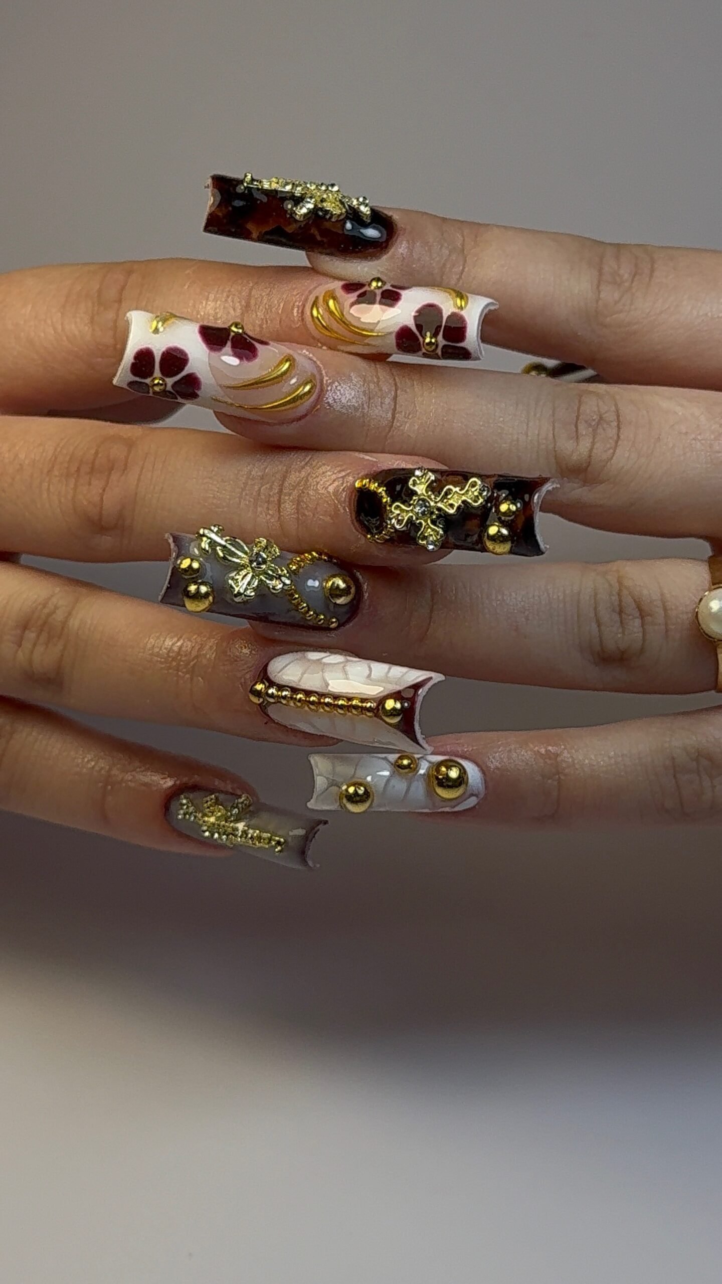 Ongles carrés longs écaille, croix dorées et fleurs bordeaux